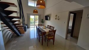 a dining room with a table and chairs and stairs at Carcano Temporarios in Villa Carlos Paz