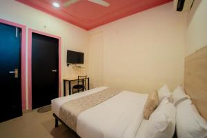 a hotel room with a bed and a tv at Capitol Square Near Railway Station in Jaipur