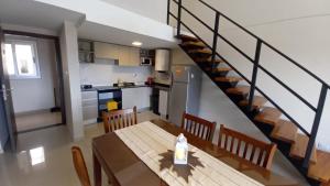 a kitchen and dining room with a table and a staircase at Carcano Temporarios in Villa Carlos Paz