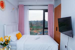 a bedroom with a bed and a large window at comfystdkiambu in Kiambu
