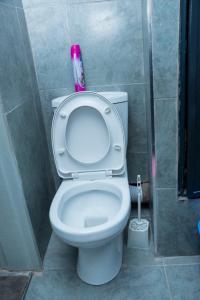 a bathroom with a toilet with a pink bottle on it at comfystdkiambu in Kiambu +50 photos