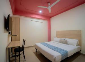 a bedroom with a bed with a red ceiling at Capitol Square Near Railway Station in Jaipur