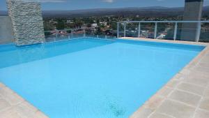 a large blue swimming pool on top of a building at Carcano Temporarios in Villa Carlos Paz