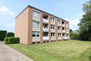 a large building with a grassy yard in front of it at Dein Apartment mit Queensize Bett im Erdgeschoss in Neukirchen-Vluyn