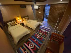 an attic bedroom with two beds and a rug at Petra Wassaif Camp in Wadi Musa