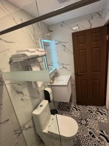 a white bathroom with a toilet and a sink at Afma Nueva Alta in Cusco