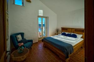 a bedroom with a bed and a blue chair at Villa Stone Lace in Kolan +43 photos