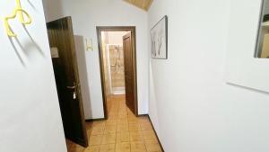 a hallway with a door and a tile floor at Baradello Apartment & Flat by ca-Sa Check in Le Bratte +64 photos