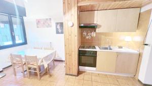 a kitchen with a table and a sink and a stove at Baradello Apartment & Flat by ca-Sa Check in Le Bratte