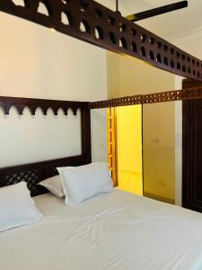 a bed with white sheets and pillows in a room at Casa Yangu in Watamu +22 photos
