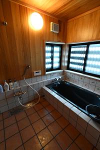 a bathroom with a bath tub and a sink at 森ノ間 大谷荘 in Myoko +34 photos