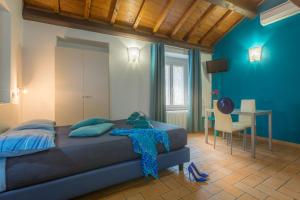 een slaapkamer met blauwe muren en een bed en een bureau bij Saffi 103 in Viterbo