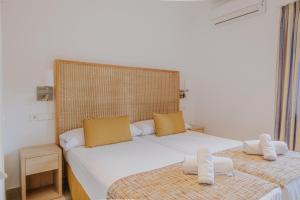 a bedroom with two beds with white sheets and yellow pillows at Villa Santo Tomas - Gabriela in Santo Tomás +31 photos