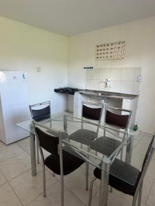 a glass table and chairs in a kitchen at Sweet home in São Luís