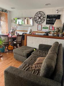 a living room with a couch and a clock on the wall at Hostal Colonial in Iquique