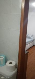 a bathroom with a toilet with a roll of toilet paper at Hostal Colonial in Iquique +28 photos
