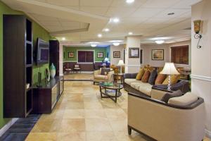 a large living room with couches and a tv at Holiday Inn Express West Palm Beach Metrocentre by IHG in West Palm Beach