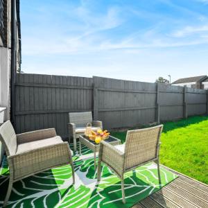 a patio with two chairs and a table and a fence at Stylish 3 Bedroom House - King Size Beds - 5 Guests - Garden & Parking 4VC in Minworth