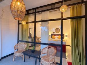 a room with a table and chairs and a bedroom at Tea Ridge Ella by SANS in Ella