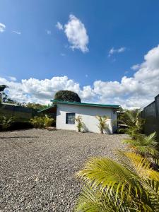 a white house with a gravel driveway at Arenal Star Luxury Studios with Private Jacuzzi in Fortuna
