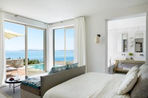 a bedroom with a bed and a view of the ocean at Eagles Villas - Small Luxury Hotels of The World in Ouranoupoli
