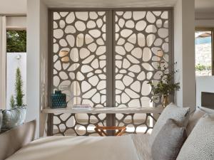 a bedroom with a window with a moroccan inspired screen at Eagles Villas - Small Luxury Hotels of The World in Ouranoupoli