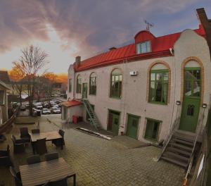 a building with a red roof and a table and benches at L Boutique Hotel in Lysekil