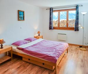 a bedroom with a large bed and a window at FeWo im Chalet Schneeflöckli in La Tzoumaz