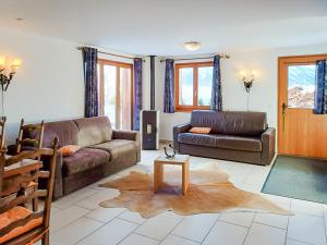 a living room with a couch and a table at FeWo im Chalet Schneeflöckli in La Tzoumaz
