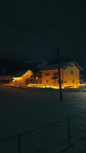 a house with lights in front of a building at night at CosAlpin Apartament in Cîrlibaba