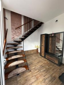 a staircase in a living room with wooden floors at CosAlpin Apartament in Cîrlibaba +4 photos