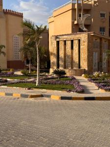a building with a palm tree and a courtyard at البيت بيتك الواحة in 6th Of October