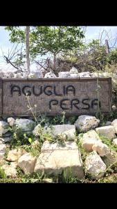 a sign on a wall with some rocks at Aguglia Persa - Double Room in Noto