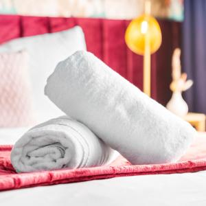 a roll of white towels on a bed at Stylish 3 Bedroom House - King Size Beds - 5 Guests - Garden & Parking 4VC in Minworth +24 photos