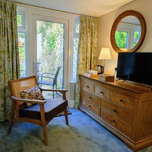a living room with a television and a dresser with a mirror at Lee House in Lynton