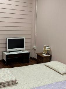 a bedroom with two beds and a television on a table at Febb x Vintage Room in Ban Ko Takhian