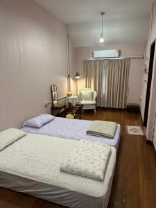 a bedroom with two beds and a living room at Febb x Vintage Room in Ban Ko Takhian