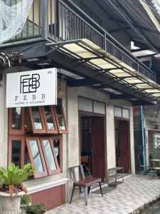 a sign on the side of a building with a chair at Febb x Vintage Room in Ban Ko Takhian