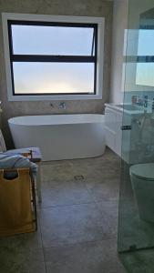 a bathroom with a bath tub and a window at Ahvenbloem Park in Kelso +28 photos