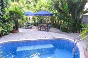 a swimming pool with a table and an umbrella at Casa Hotel Jardin Azul in Cali