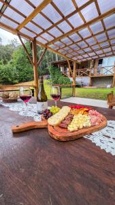 a plate of food and two glasses of wine on a table at Rancho do Lagarto Pedra Azul - JACUZZI E ÁREA GOURMET in Domingos Martins
