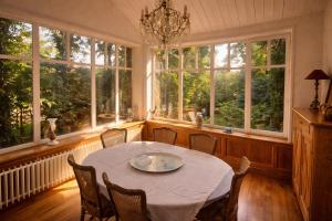 a dining room with a table and chairs and windows at Le Pré du Dimanche in Maringues +14 photos