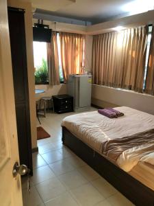 a bedroom with a bed in a room with a window at จอมเทียน ซีไซด์ เกสเฮ้าส์ in Jomtien Beach