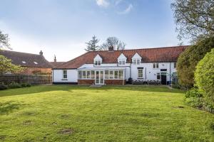 an exterior view of a house with a large yard at Nelson Lodge in Burnham Market