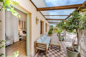 an outdoor patio with a couch and chairs and plants at Casa Romana Hotel Boutique in Seville