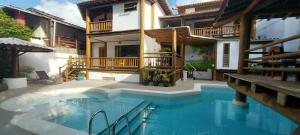 a house with a swimming pool in front of a house at Aloha Residence I in Praia do Forte