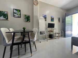 a living room with a table and chairs and a television at Hayat Apartment Digos City in Dawis