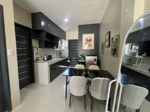 a kitchen and dining room with a table and chairs at Hayat Apartment Digos City in Dawis +5 photos