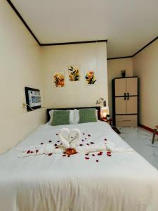 a bedroom with a white bed with flowers on it at G & B Transient House in San Jose