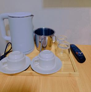 a wooden table with two cups and plates and a blender at G & B Transient House in San Jose